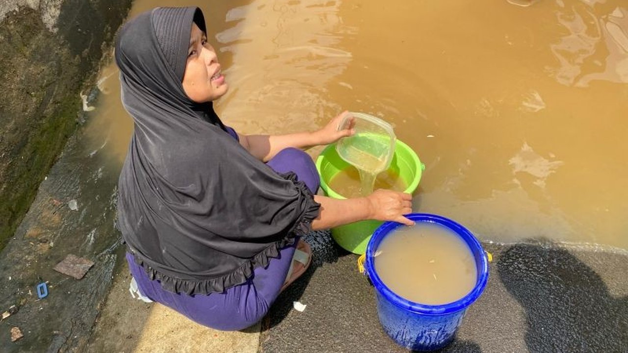 Kekurangan air bersih pascabanjir di Pengadegan, Jakarta Selatan, membuat warga terpaksa menggunakan air banjir untuk mencuci piring dan kesulitan mendapatkan air minum.