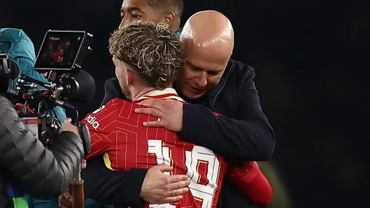 Gelandang Liverpool, Harvey Elliot dipeluk sang manajer, Arne Slot. Elliot mencetak gol kemenangan Liverpool atas PSG pada leg pertama 16 besar Liga Champions 2024/2025 di Parc des Princes, P