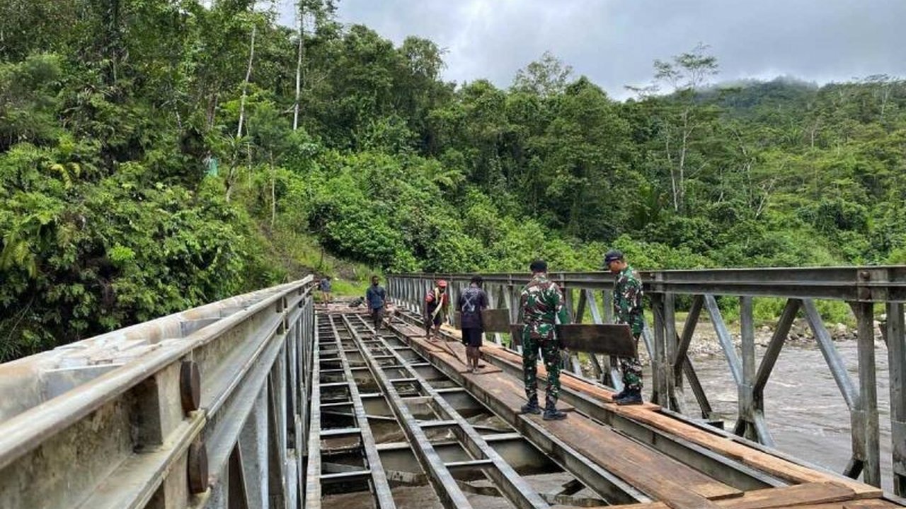 Satgas Yonif 641/Bru bergotong royong dengan warga memperbaiki jembatan penghubung Distrik Apalapsili, Yalimo-Papua Pegunungan, yang rusak parah dan mengancam keselamatan warga.