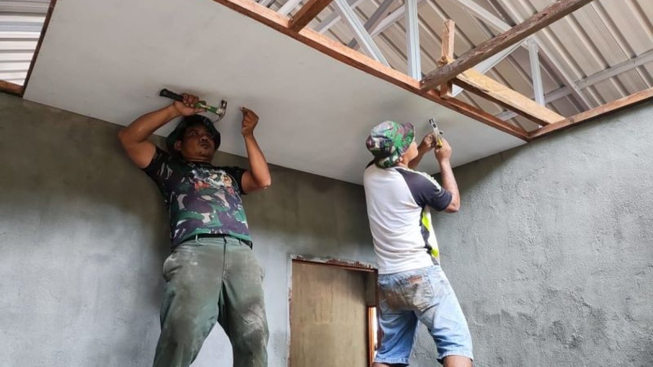 Personel Satgas TMMD ke-123 Kodim 1708/BN di Biak, Papua, memasang plafon 10 rumah warga Kampung Kbusdori, meningkatkan kenyamanan dan keamanan hunian warga.