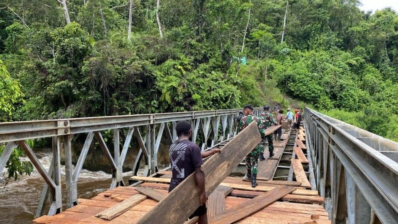 Satgas Yonif 641/Bru TNI AD membantu warga Distrik Apalapsili, Kabupaten Yalimo, Papua Pegunungan, memperbaiki jembatan vital yang rusak parah, sehingga akses dan perekonomian warga kembali lancar.