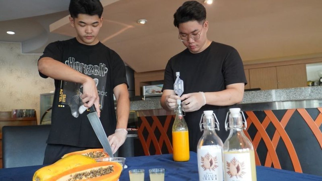 Dua mahasiswa PCU Surabaya ciptakan wine pepaya Bangkok dengan cita rasa unik dan nilai jual tinggi, solusi mengatasi permasalahan harga jual pepaya yang rendah.