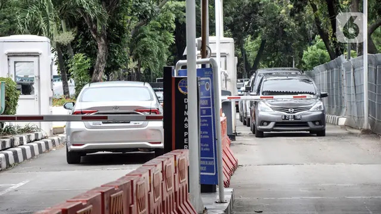 Mobil pengunjung melintasi pintu parkir IRTI Monas, Jakarta, Rabu (15/2/2023). Mobil yang telah lolos uji emisi akan dikenakan tarif parkir sebesar Rp 4.000 per jam, sedangkan yang belum lolo
