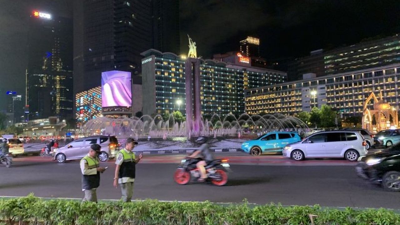Arus lalu lintas di Bundaran HI ramai lancar pada malam takbiran Idul Fitri 1446 H, polisi bubarkan konvoi kendaraan untuk mencegah kemacetan.