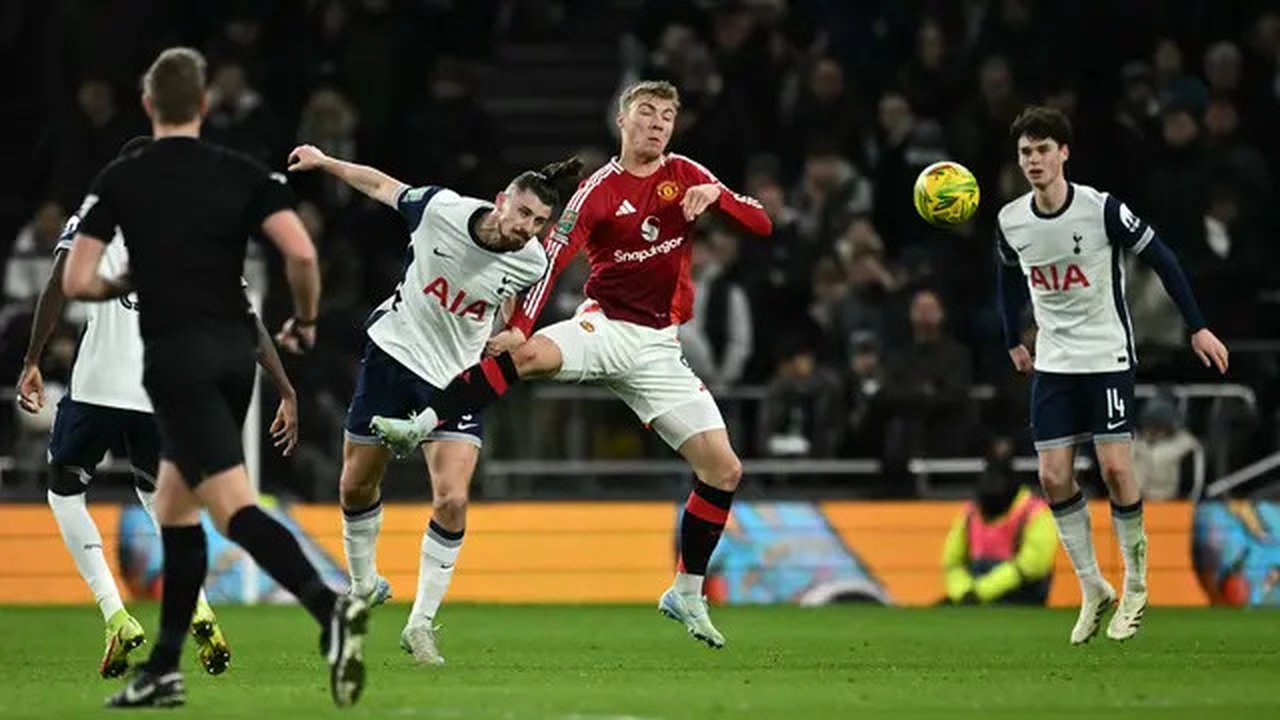 Bek Tottenham Hotspur asal Rumania #06 Radu Dragusin (C) berebut bola dengan penyerang Manchester United asal Denmark #09 Rasmus Hojlund selama pertandingan perempat final Piala Liga Inggr