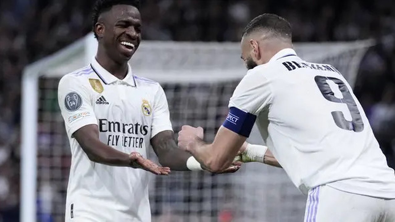 Striker Real Madrid, Karim Benzema (kanan), merayakan gol yang dicetaknya ke gawang Liverpool bersama Vinicius Junior yang memberinya assist dalam pertandingan leg kedua 16 besar Liga Champio