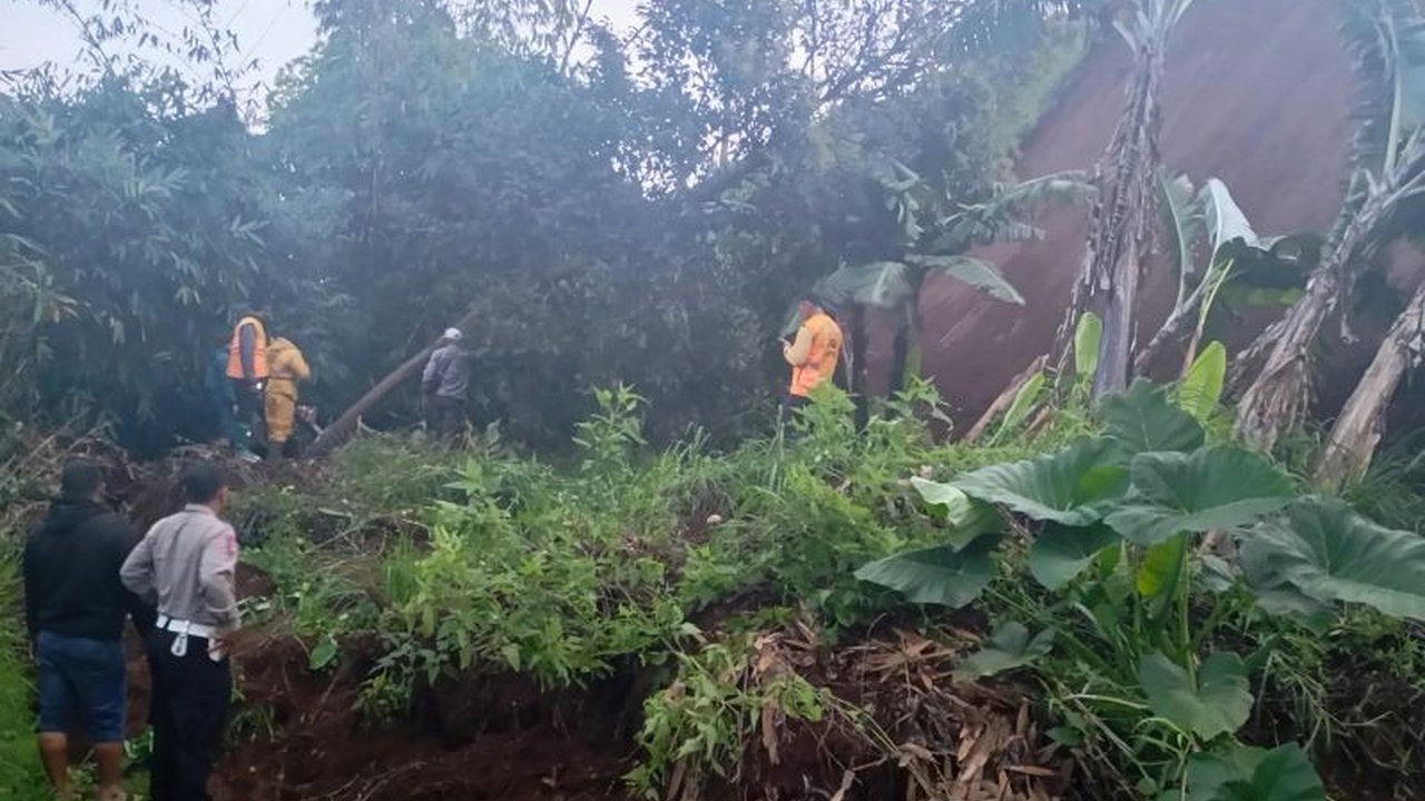 Jalan Raya Pangalengan-Cimaung lumpuh total akibat longsor setelah hujan deras mengguyur wilayah tersebut; petugas gabungan langsung melakukan evakuasi material longsor.
