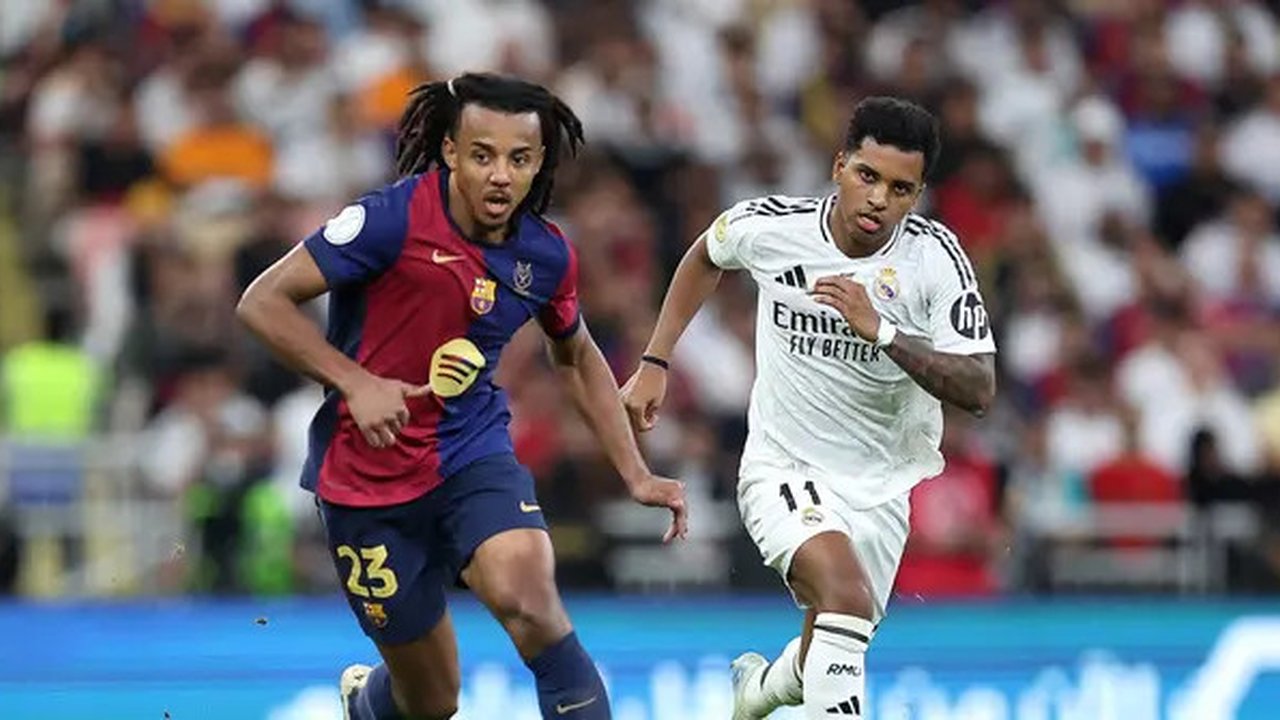 Bek Barcelona asal Prancis Jules Kounde berlari membawa bola melewati penyerang Real Madrid asal Brasil Rodrygo selama pertandingan final Piala Super Spanyol antara Real Madrid dan Barcelo
