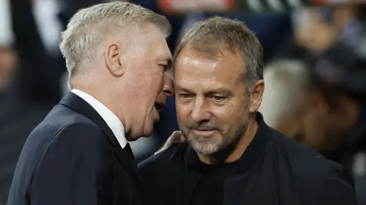 Pelatih Real Madrid, Carlo Ancelotti dan pelatih Barcelona, Hansi Flick berinteraksi dalam laga El Clasico di Estadio Santiago Bernabeu, Senin (27/10/2024) dini hari WIB. (AFP/Oscar Del Pozo)