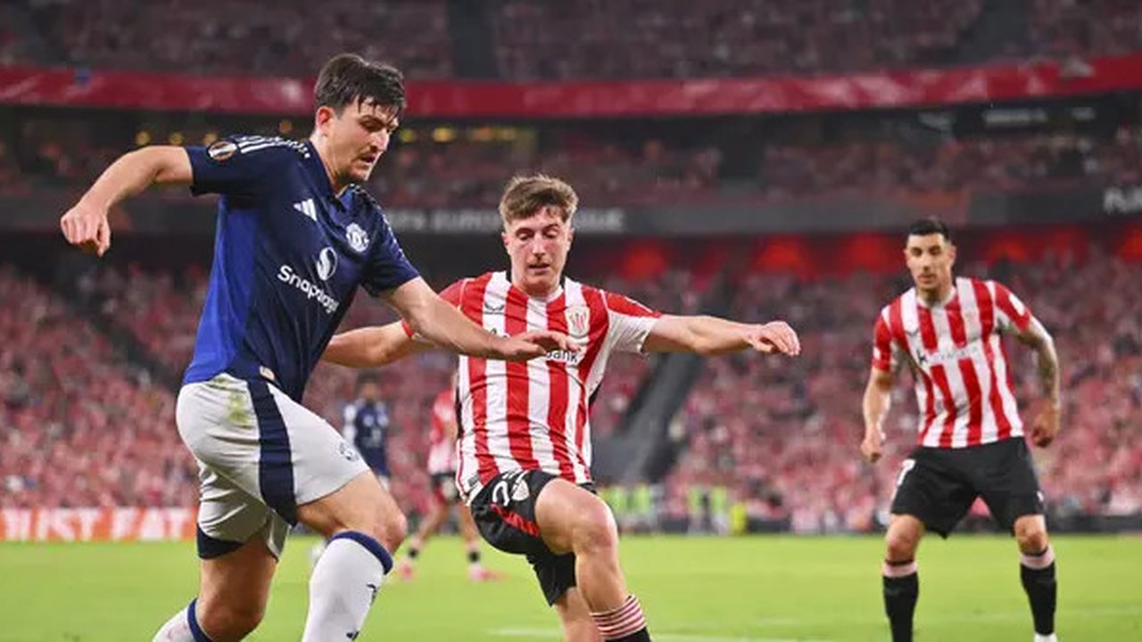 Bek MU, Harry Maguire, berupaya melewati adangan pemain Athletic Bilbao pada leg 1 semifinal Liga Europa 2024/2025 di Stadion San Mames, Jumat (2/5/2025) dini hari WIB. (AP Photo/Miguel Oses)
