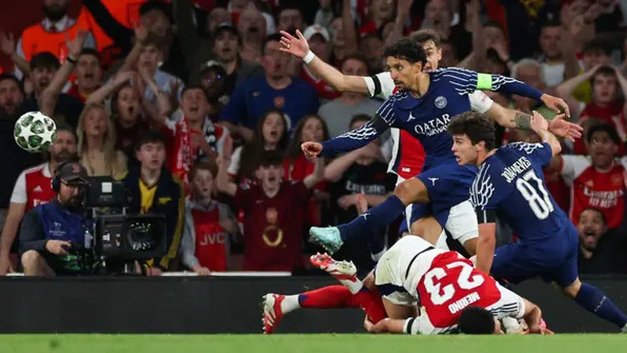 Gelandang Arsenal asal Spanyol Mikel Merino (bawah) ditekel oleh gelandang Paris Saint-Germain asal Portugal Joao Neves (kanan) saat bek Paris Saint-Germain asal Brasil Marquinhos (belakan