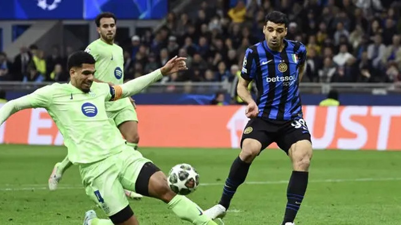 Bek Barcelona asal Uruguay #04, Ronald Federico Araujo da Silva (kiri), dan penyerang Inter Milan asal Iran #99, Mehdi Taremi, berebut bola selama pertandingan leg kedua semifinal Liga Cha