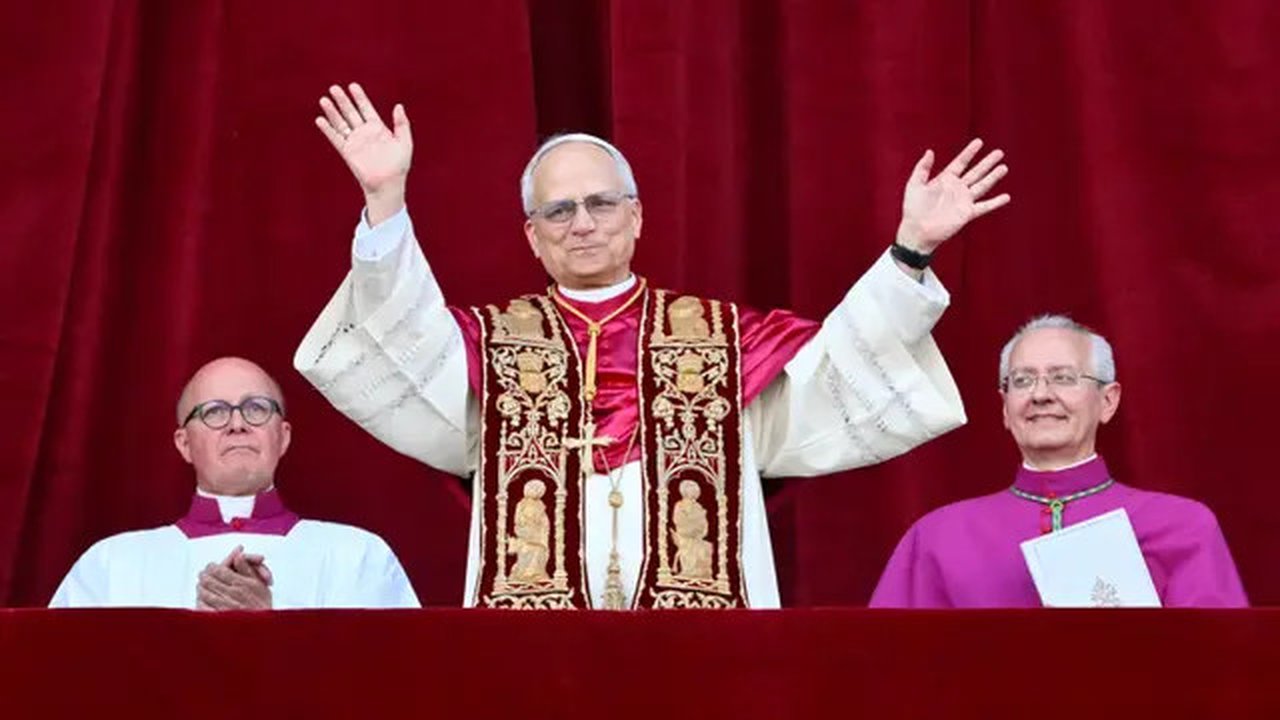 Paus Leo XIV yang baru terpilih, Robert Francis Prevost melambaikan tangan dari balkon loggia pusat utama Basilika Santo Petrus untuk pertama kalinya, setelah para kardinal mengakhiri konklaf