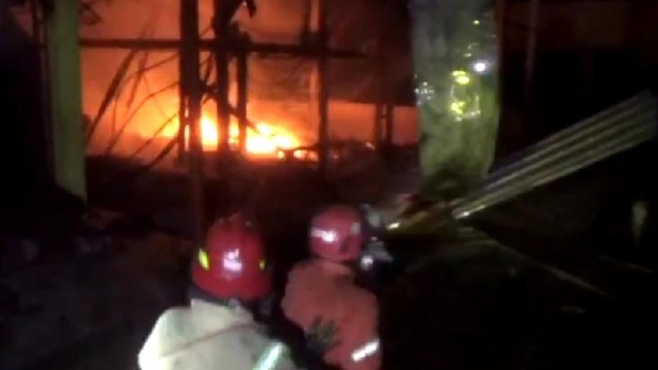 Kebakaran besar menghanguskan puluhan lapak pedagang di Pasar Mojoduwur, Jombang, Jawa Timur; diduga akibat korsleting listrik, pedagang berupaya menyelamatkan barang dagangan mereka.