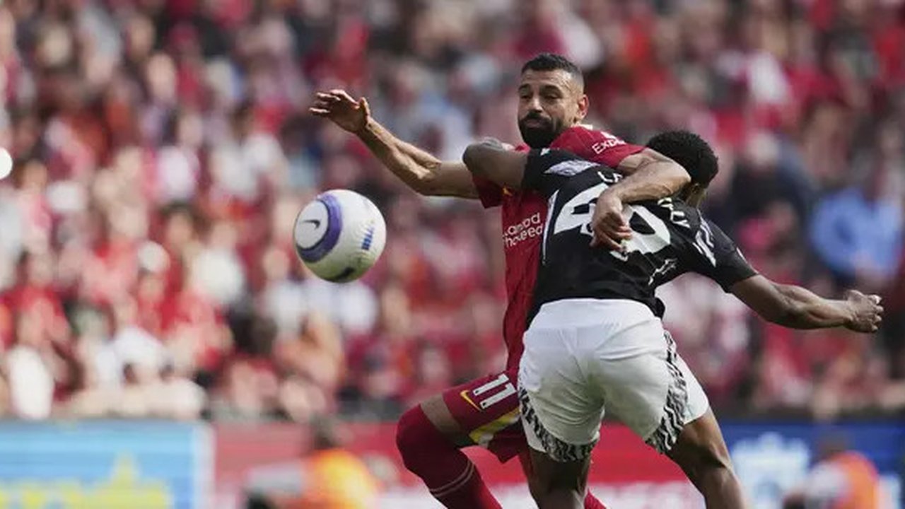 Bintang Liverpool, Mohamed Salah, berduel dengan pemain Arsenal, Myles Lewis-Skelly, dalam laga pekan 36 Premier League 2024/2025 di Anfield, Minggu (11/5/2025). (AP Photo/Jon Super)