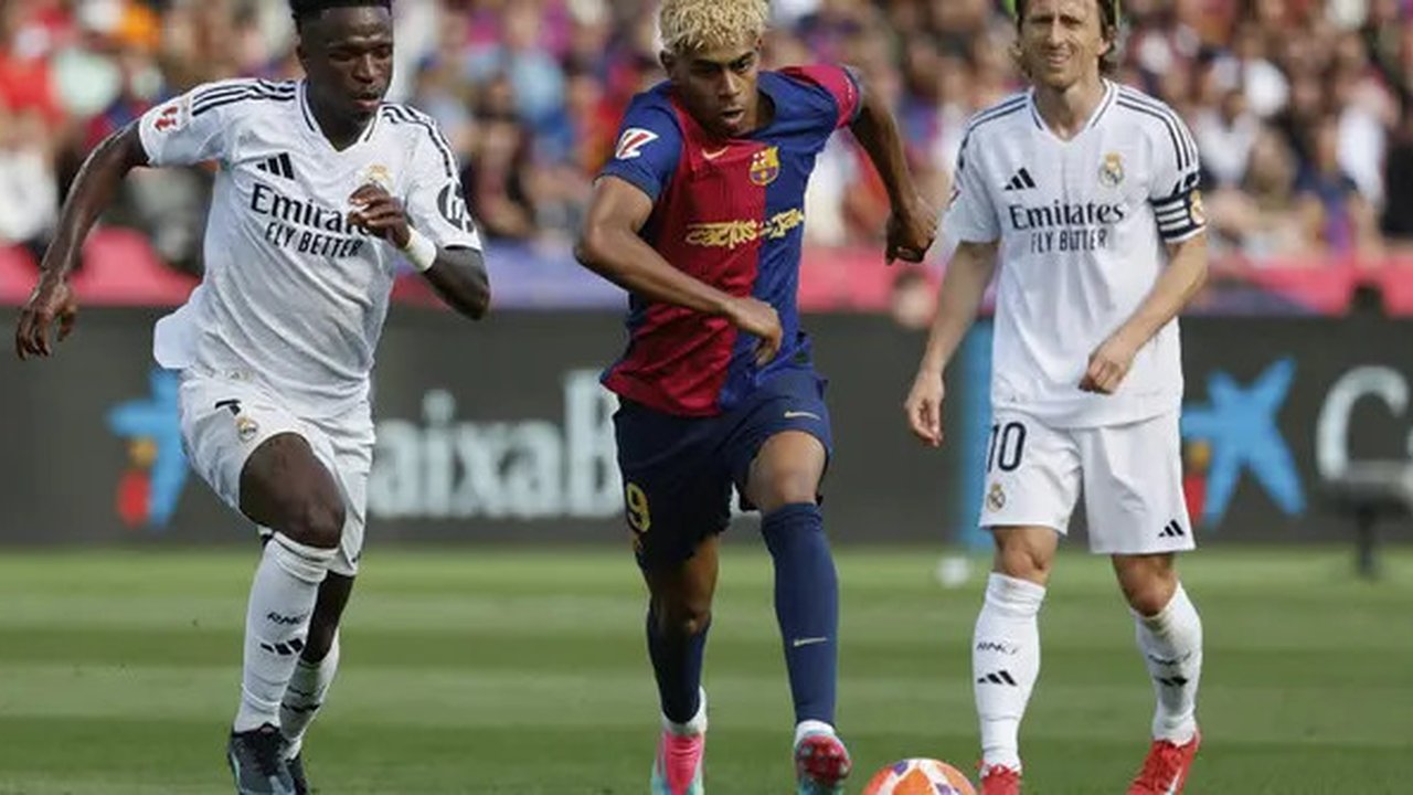 Penyerang Real Madrid, Vinicius Junior, berduel dengan winger Barcelona, Lamine Yamal, pada laga pekan ke-35 La Liga di Estadi Olimpic Lluis Companys, Minggu (11/5/2025) malam WIB. Da