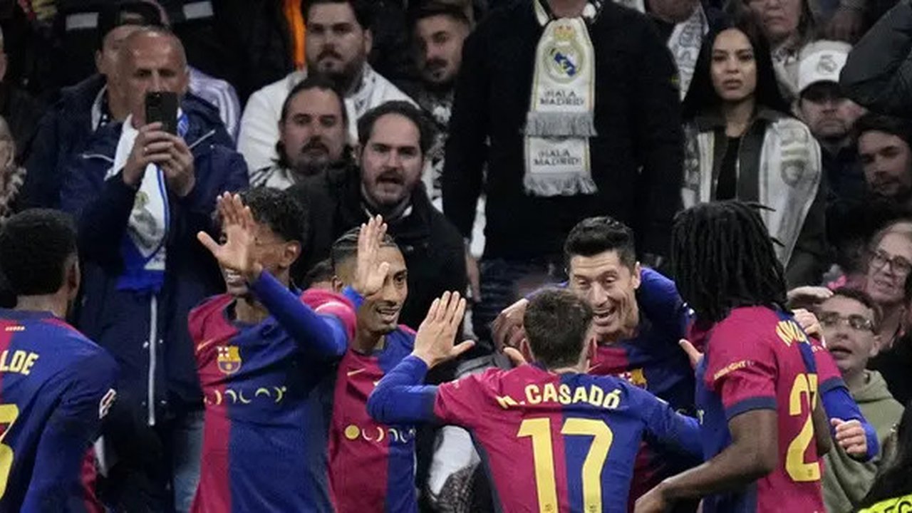 Pemain Barcelona merayakan gol pertama Robert Lewandowski saat menghadapi Real Madrid dalam laga jornada 11 La Liga Spanyol di Santiago Bernabeu, Minggu (27/10/2024) dini hari WIB. Barcelona
