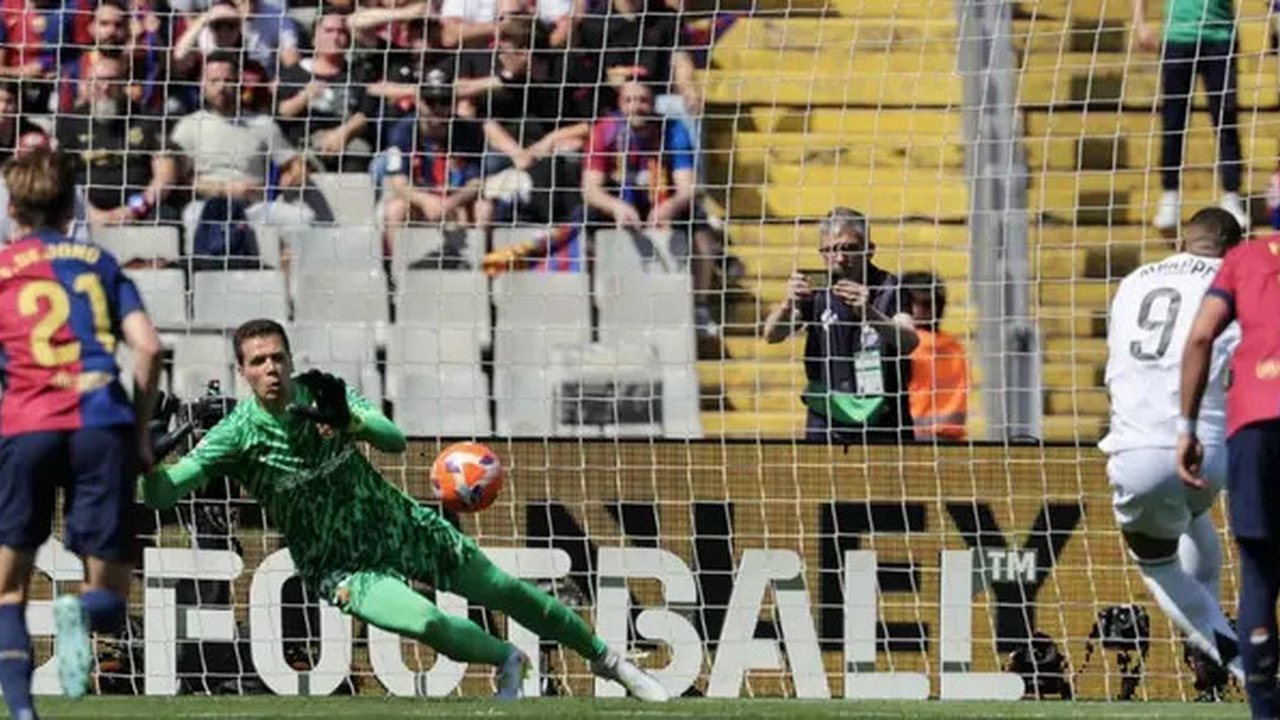 Pemain depan Real Madrid asal Prancis #09, Kylian Mbappe, mencetak gol dari titik penalti ke gawang Barcelona asal Polandia #25, Wojciech Szczesny, selama pertandingan sepak bola liga Span