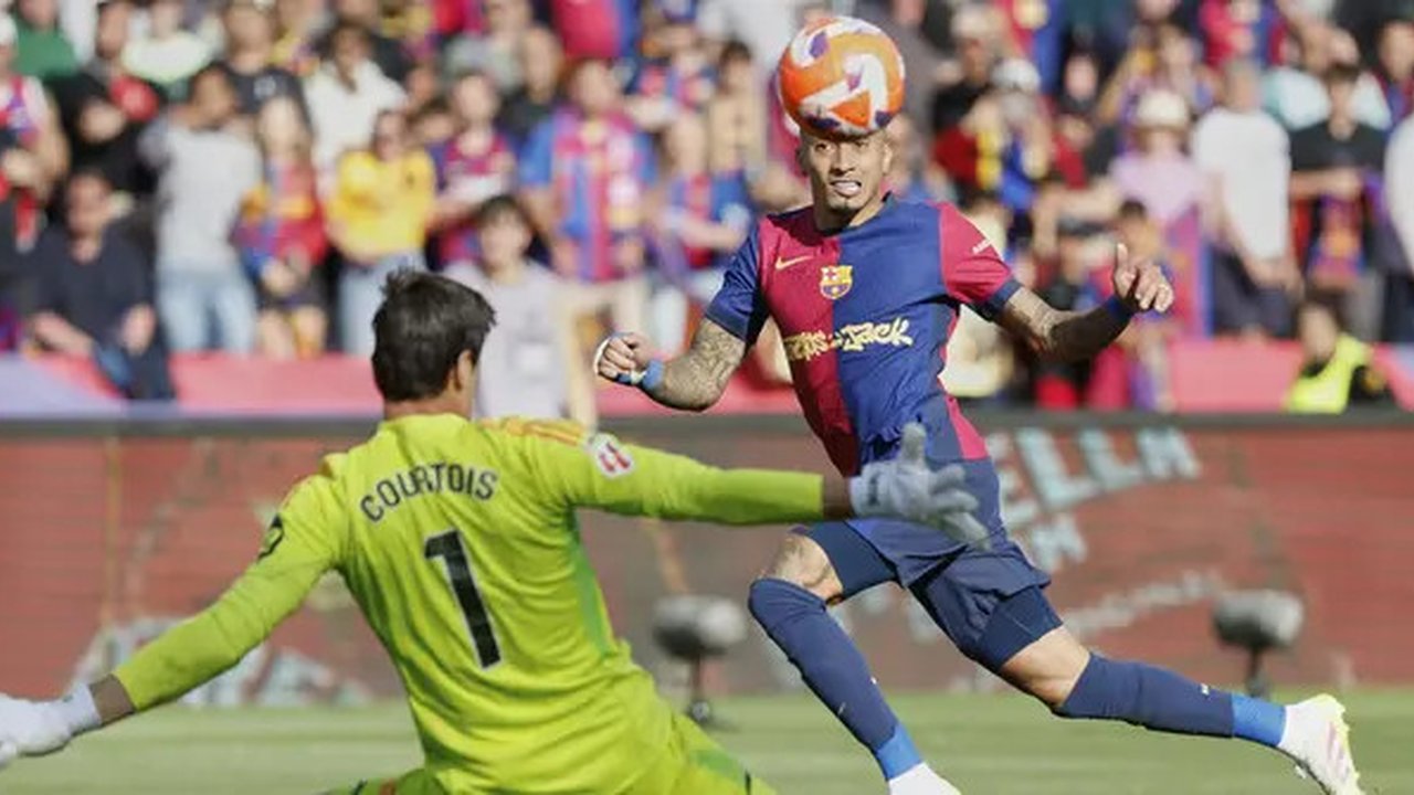 Pemain Barcelona, Raphinha mencetak gol ke gawang Real Madrid yang dijaga Thibaut Courtois dalam laga lanjutan Liga Spanyol 2024/2025 di Estadi Olimpic Lluis Companys, Barcelona, Spanyol, Min