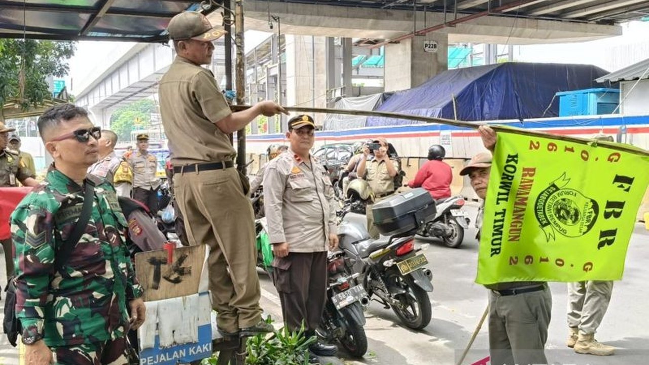 Petugas gabungan menurunkan atribut ormas di sejumlah titik strategis Pulogadung, Jakarta Timur, untuk menjaga ketertiban dan netralitas ruang publik.