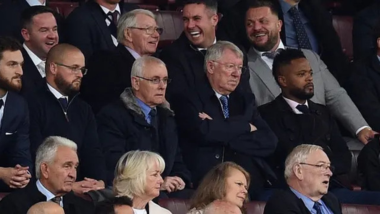 Mantan manajer Manchester United, Sir Alex Ferguson, duduk di kotak direktur bersama mantan pemain United, bek Prancis, Patrice Evra, selama pertandingan Liga Primer Inggris antara Manches