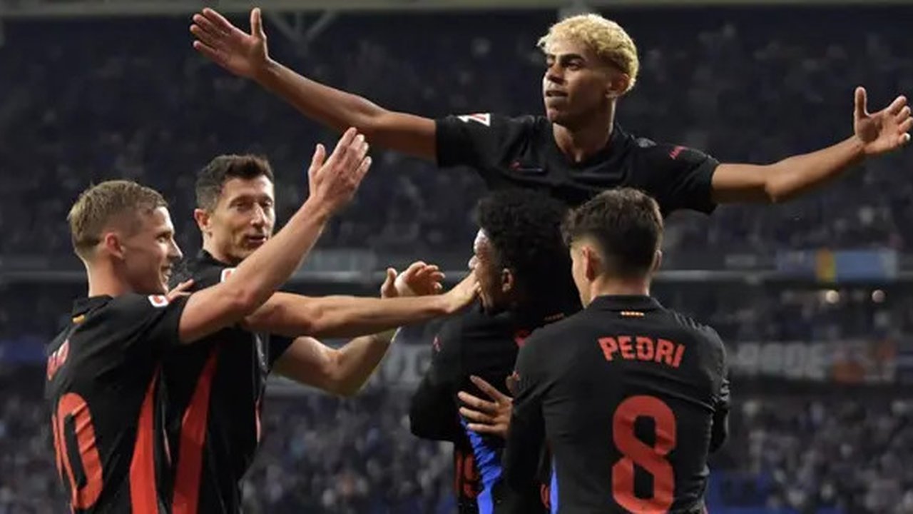 Pemain depan Barcelona asal Spanyol #19, Lamine Yamal (C), merayakan gol pertama timnya selama pertandingan sepak bola liga Spanyol antara RCD Espanyol dan FC Barcelona di Stadion RCDE di