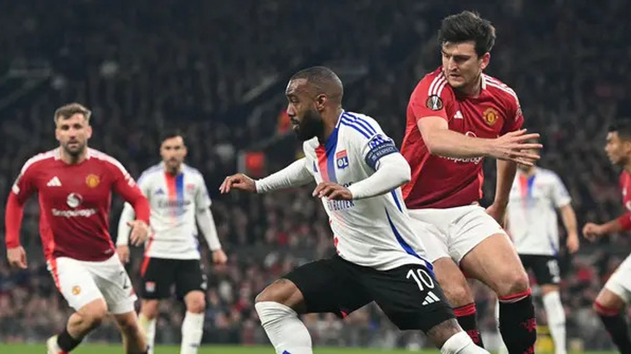 Pemain Manchester United, Harry Maguire berusaha merebut bola dari kaki pemain Lyon, Alexandre Lacazette dalam laga leg 2 perempat final Liga Europa 2024/2025 di Old Trafford, Manchester, Ing
