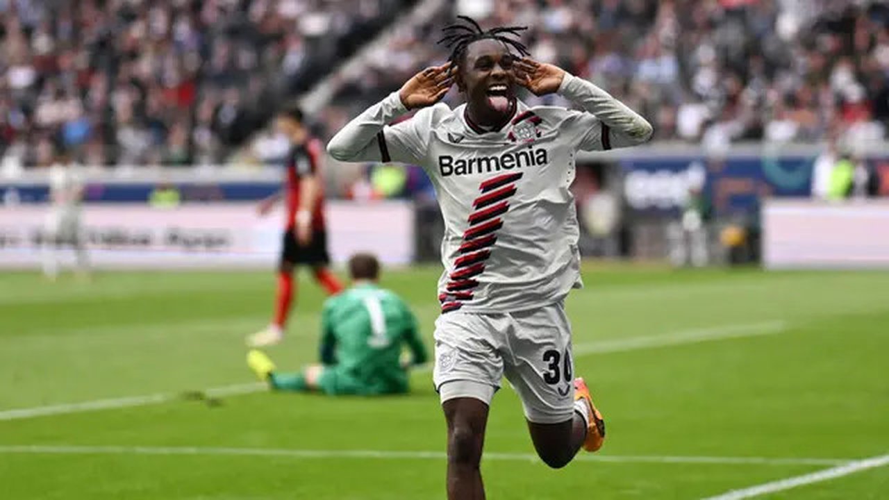 Pemain Bayer Leverkusen, Jeremie Frimpong, melakukan selebrasi setelah mencetak gol ke gawang Eintracht Frankfurt pada laga Liga Jerman di Stadion Deutsche Bank Park, Senin (6/5/2024). (AFP/K