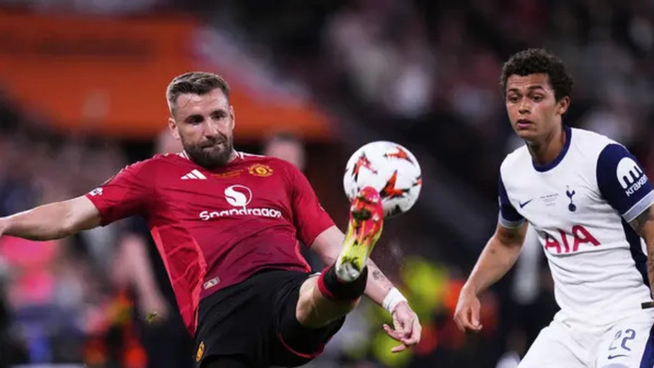 Bek Manchester United Luke Shaw berebut bola dengan pemain Tottenham Brennan Johnson dalam laga final Liga Europa di San Mames, Kamis (22/5/2025). (AP Photo/Manu Fernandez)