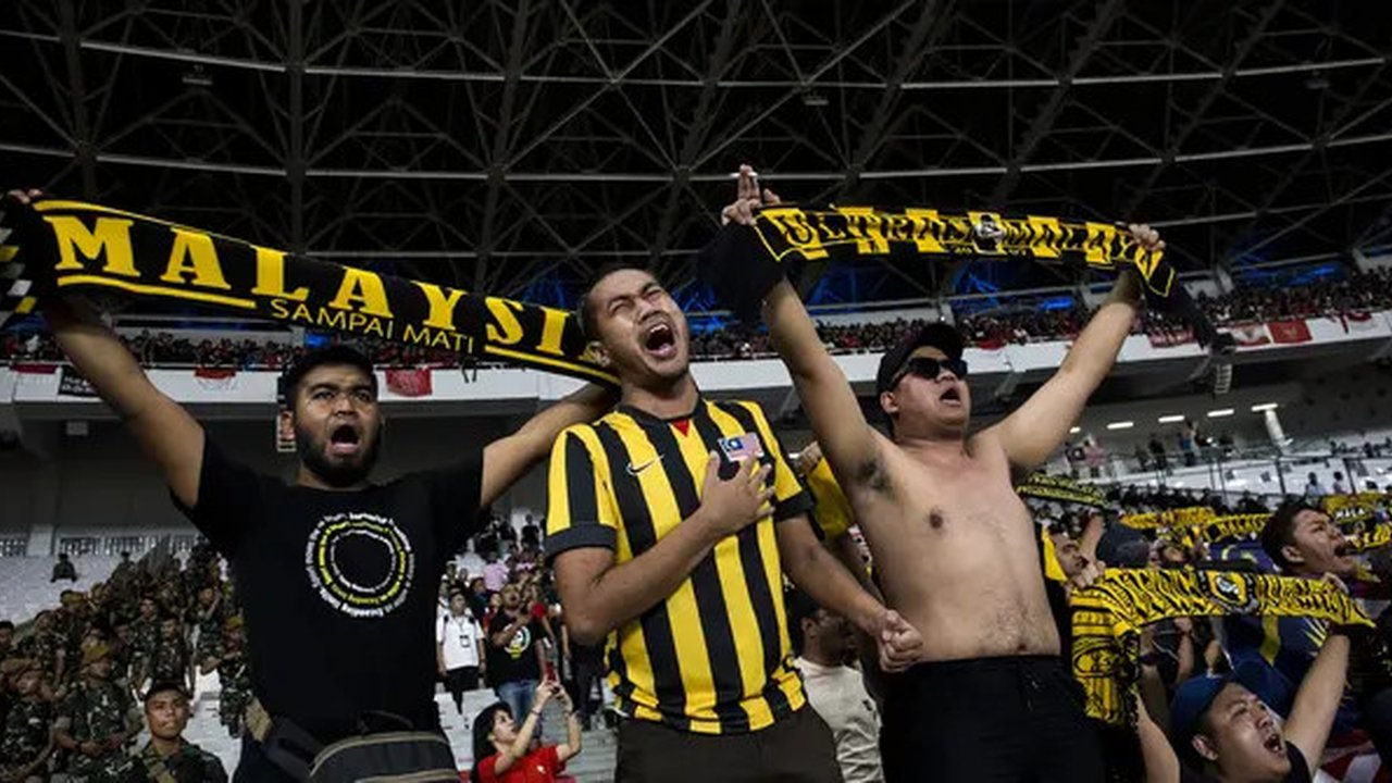 Suporter Malaysia memberikan dukungan saat melawan Timnas Indonesia pada laga Kualifikasi Piala Dunia 2022 di SUGBK, Jakarta, Kamis (5/9). Indonesia kalah 2-3 dari Malaysia. (Bola.com/Vitalis