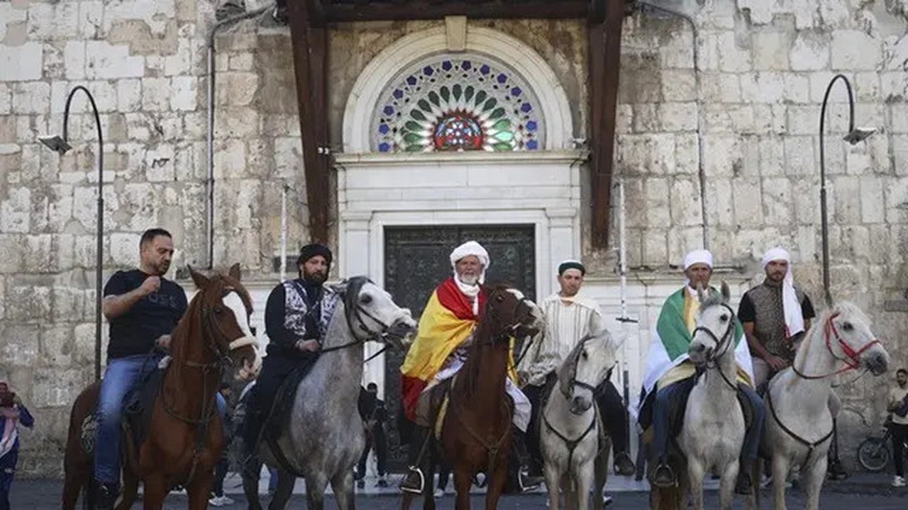 Jemaah haji, termasuk tiga orang dari Spanyol, berpose dengan kuda mereka di luar Pasar al-Hamidiyah di Damaskus, Suriah, 21 April 2025, selama perjalanan berkuda selama berbulan-bula