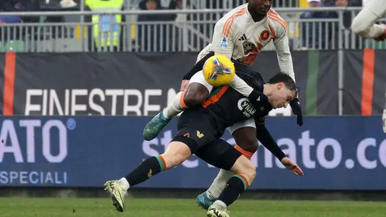 Pemain AS Roma, Evan Ndicka (atas) berebut bola dengan pemain Venezia, Alessio Zerbin dalam laga lanjutan Liga Italia 2024/2025 di Pier Luigi Penzo Stadium, Venice, Italia, Minggu (10/02/2025