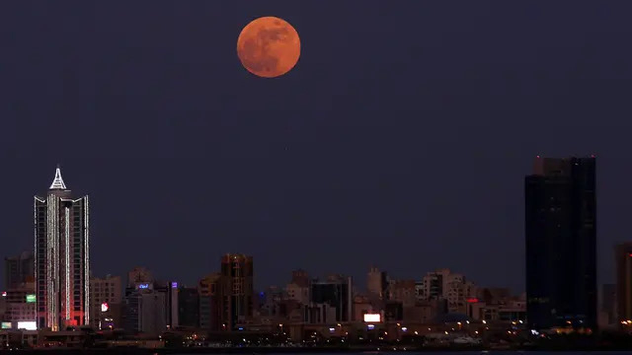 Bulan Purnama Stroberi atau Strawberry Full Moon muncul di atas Kota Kuwait, pada Kamis (24/6/2021). Strawberry Full Moon adalah istilah yang diambil dari hikayat atau cerita tradisi dari suk