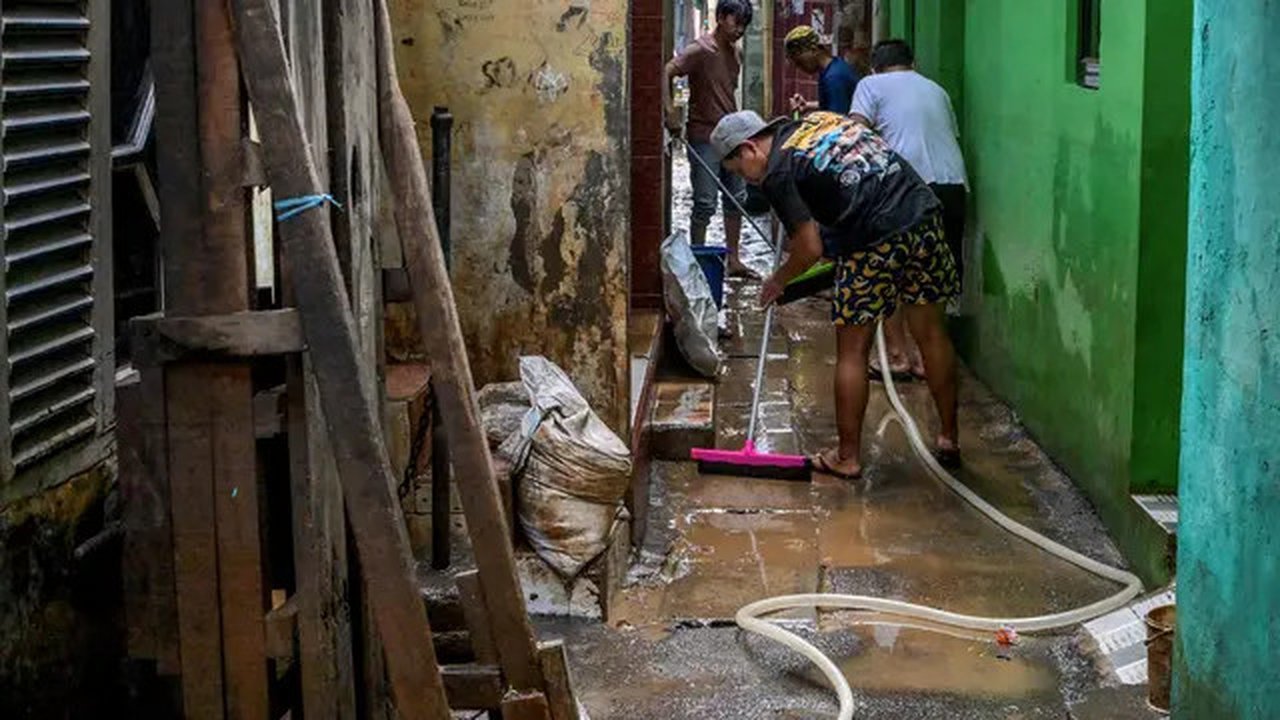Sejumlah warga membersihkan jalanan berlumpur setelah terendam banjir di Jakarta, pada Senin (7/7/2025).