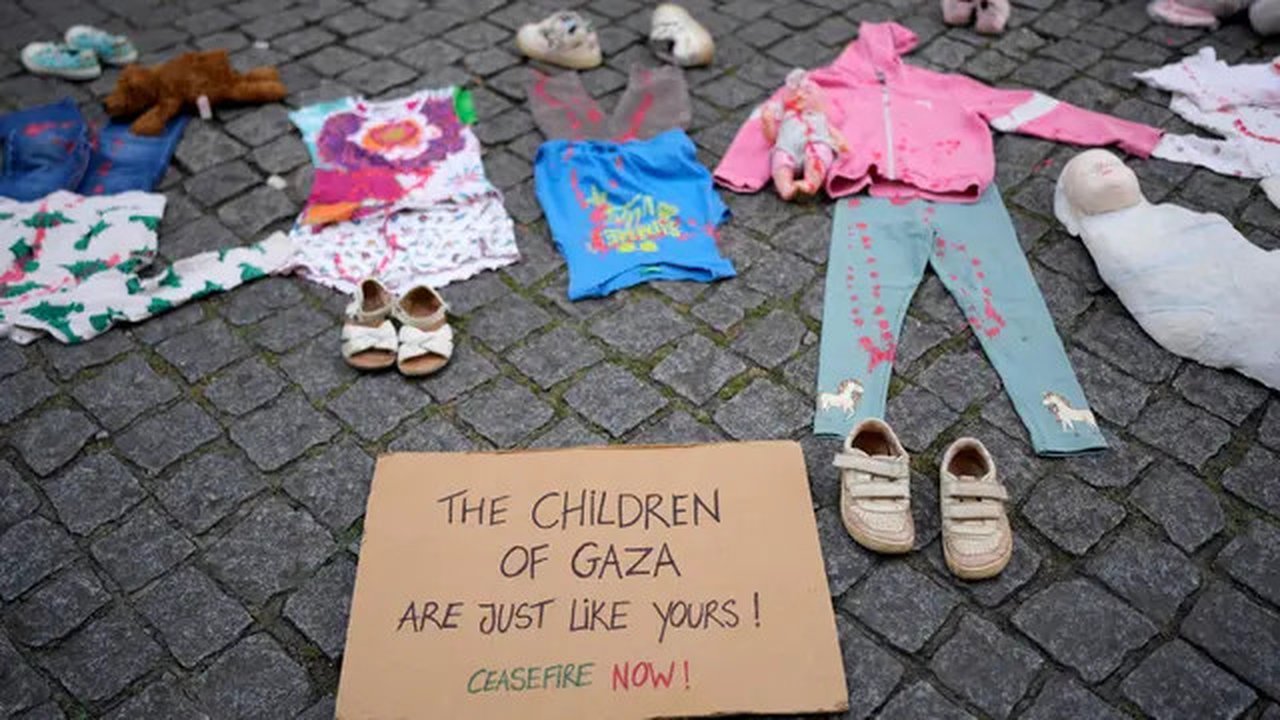 Sebuah instalasi pakaian dan mainan anak-anak tersebar di sepanjang jalan Carmo di pusat kota Lisbon, Portugal, Jumat, 30 Mei 2025. (AP Photo/Armando Franca)