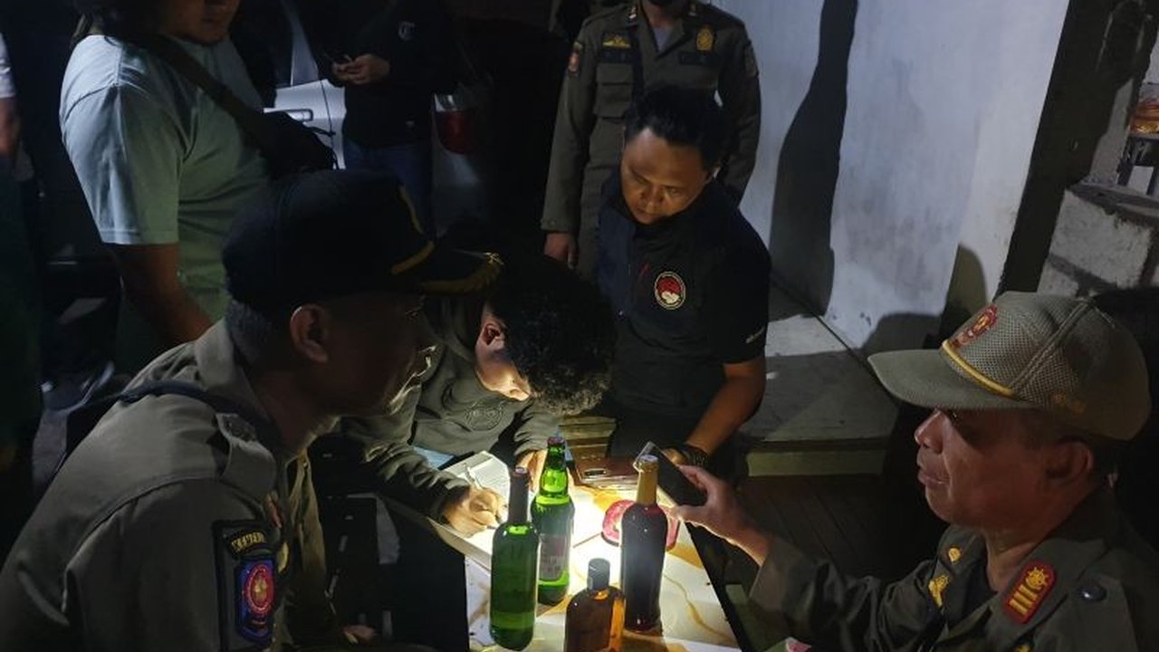 Puluhan botol minuman keras disita dalam Razia Miras Tulungagung di warkop karaoke, mengungkap praktik penjualan tanpa izin dan perizinan kedaluwarsa yang membuat penasaran.
