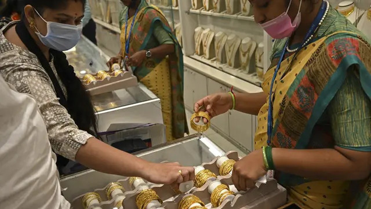 Seorang pelanggan (kiri) memeriksa gelang emas selama festival Hindu 'Akshaya Tritiya', hari keberuntungan dalam kalender Hindu untuk membeli barang-barang berharga, di ruang pamer perhias