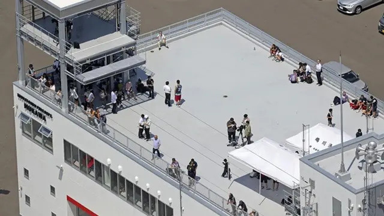 Warga berlindung di atap sebuah pos pemadam kebakaran di Kota Mukawa, Hokkaido, Jepang utara, Rabu, (30/7/2025), setelah gempa dahsyat magnitudo di wilayah Timur Jauh Rusia memicu peringat