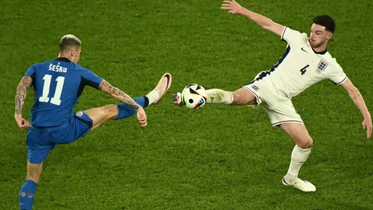 Penyerang Slovenia #11 Benjamin Sesko berebut bola dengan gelandang Inggris #04 Declan Rice dalam duel matchday terakhir Grup C Euro 2024 di RheinEnergieStadion, Cologne, Rabu, (26/6/2024). (