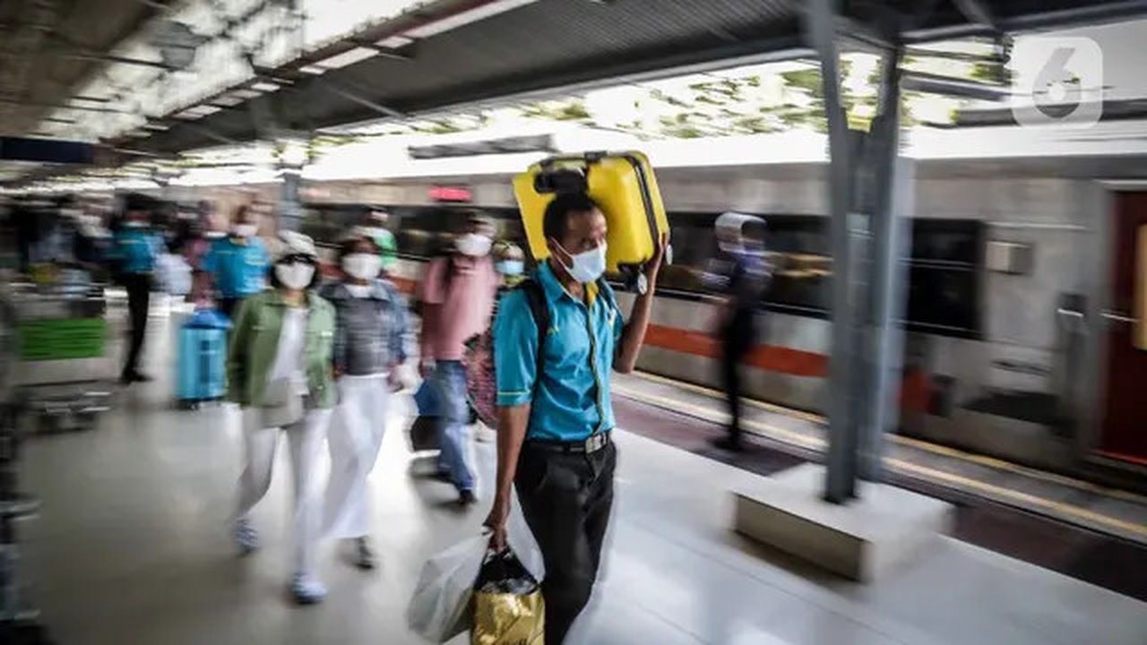 Seorang porter membawa barang penumpang kereta api Dharmawangsa dari Surabaya tiba di Stasiun Pasar Senen, Jakarta, Kamis (5/5/2022). Sebanyak 38.400 penumpang yang berangkat dari seluruh