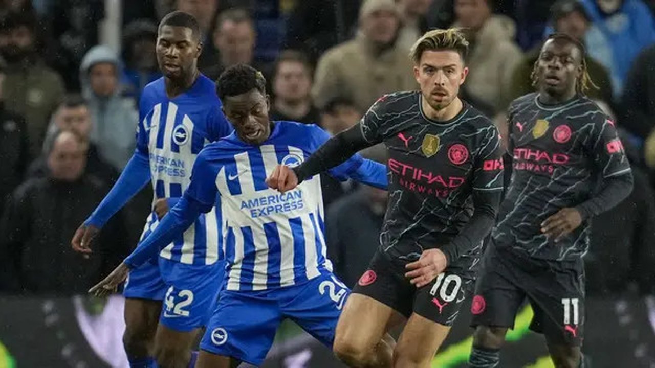 Jack Grealish dari Manchester City, kanan depan, berebut bola dengan pemain Brighton Carlos Baleba selama pertandingan sepak bola Liga Premier Inggris antara Brighton dan Manchester City d