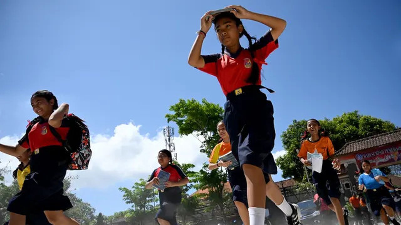 Sejumlah pelajar berlari saat mengambil bagian dalam latihan simulasi gempa bumi dan tsunami di Jimbaran, Bali (5/11/2019). Latihan dilakukan untuk memberikan pengajaran kepada siswa agar men
