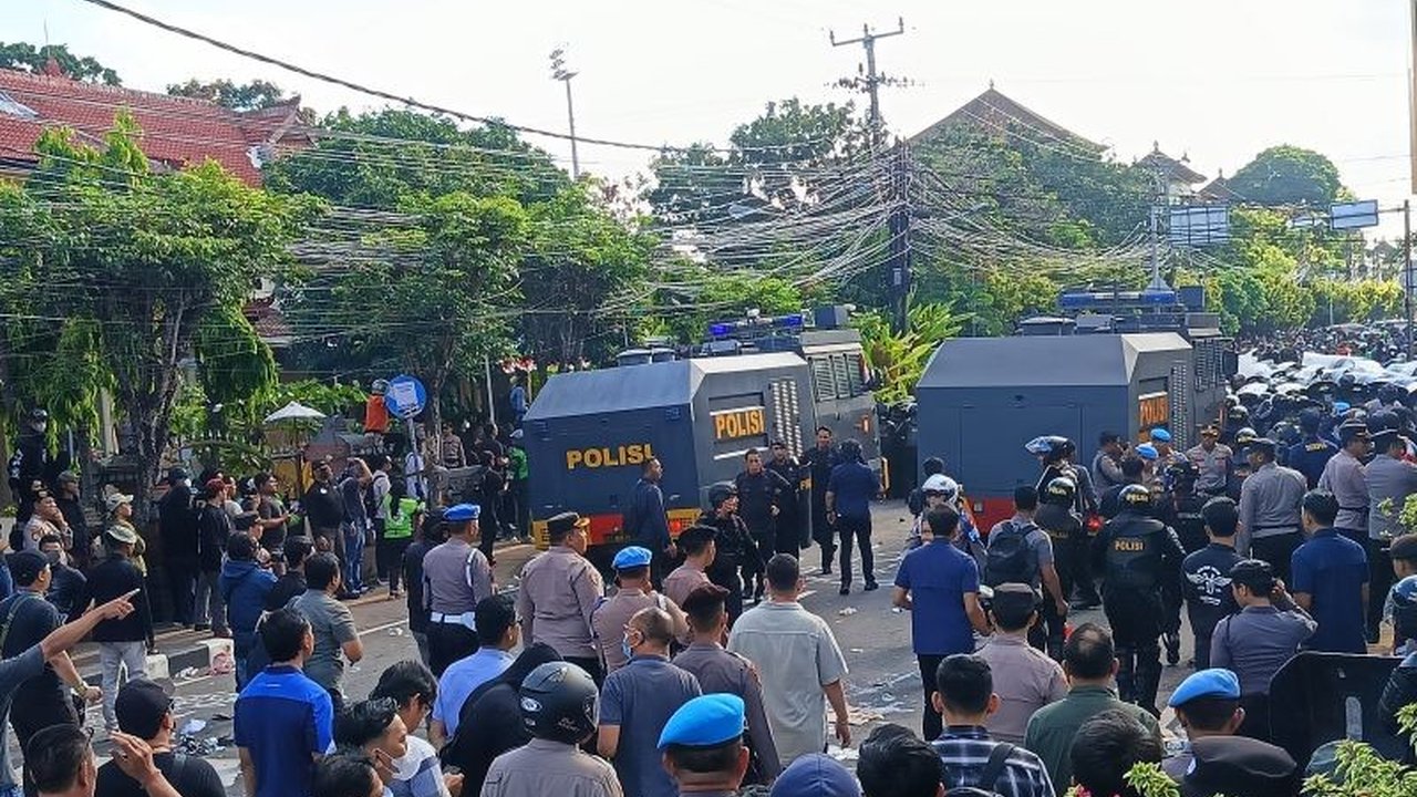 Aksi Kericuhan Demo Bali di depan Mapolda Denpasar berujung bentrok antara massa dan aparat kepolisian, memaksa polisi mengerahkan kendaraan taktis dan gas air mata.