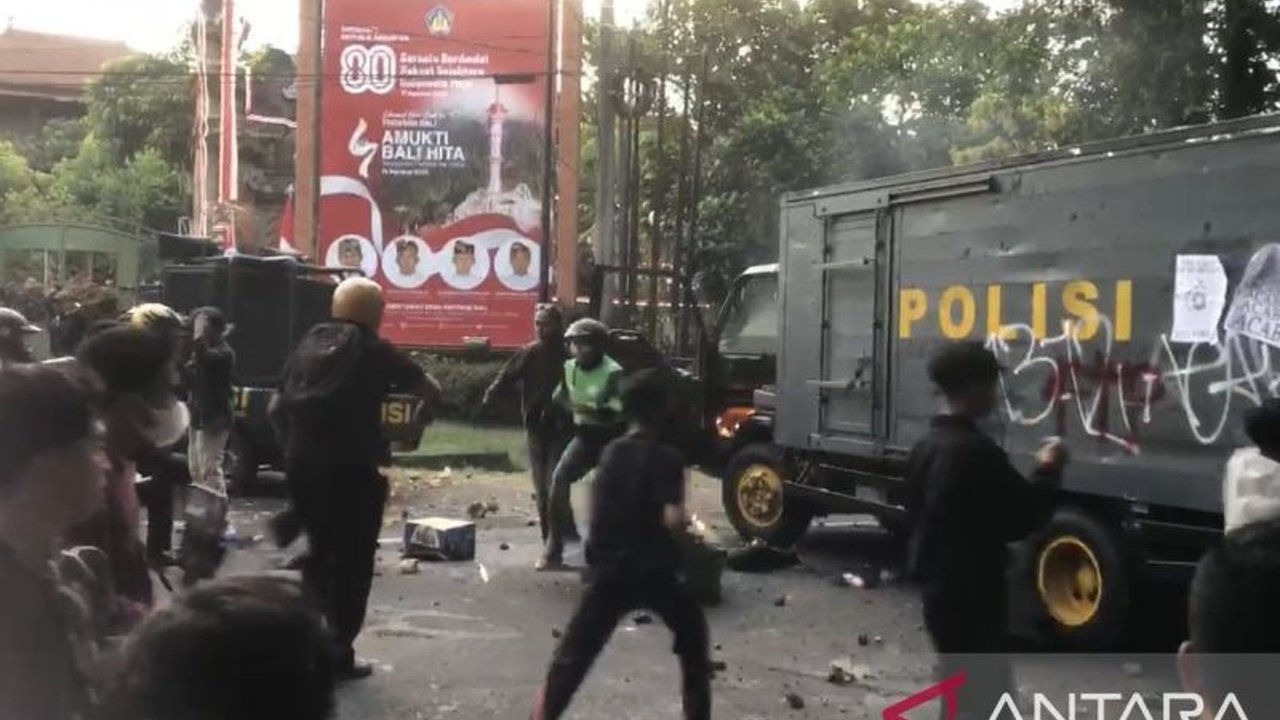 Seorang personel Polresta Denpasar dilarikan ke rumah sakit setelah mobil samapta yang dikendarainya diserang dan dibakar massa aksi di Kantor DPRD Bali. Simak kronologi Polisi Denpasar diserang massa yang anarkis.