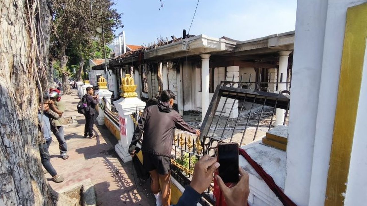 Pascakejadian Kebakaran Gedung Grahadi di Surabaya, warga berbondong-bondong datang untuk mendokumentasikan dampaknya. Simak detail kerugian dan ruangan yang hangus!