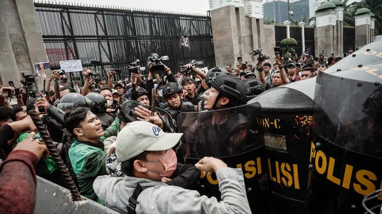 Pengunjuk rasa berusaha bertahan dan melawan dengan melempar botol air plastik. (YASUYOSHI CHIBA/AFP)