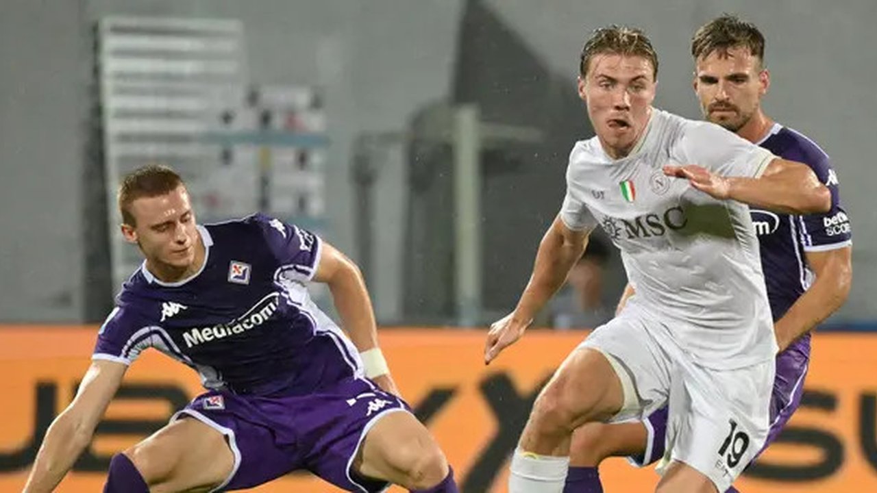 Striker Napoli, Rasmus Hojlund (tengah), mencoba melewati adangan dua pemain Fiorentina pada pekan 4 Liga Italia 2025/2026, Minggu (14/9/2025) dini hari WIB. (Alberto PIZZOLI / AFP)