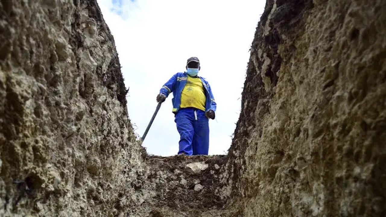 Seorang penggali makam melihat ke dalam kuburan di Pemakaman Motherwell di Port Elizabeth, Afrika Selatan pada 4 Desember 2020. Menteri Kesehatan Afrika Selatan, Zweli Mkhize pada Rabu (9/12/