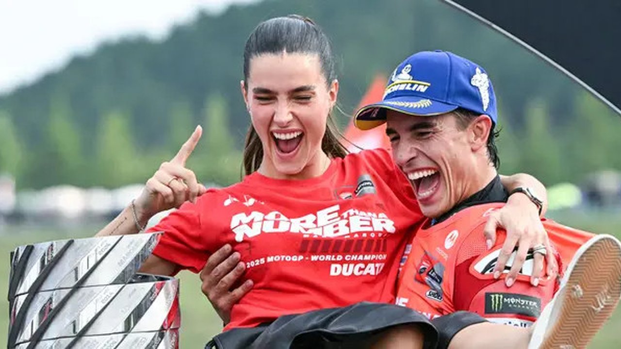 Pembalap Ducati Lenovo, Marc Marquez, bersama kekasihnya, Gemma Pinto, merayakan keberhasilan menjuarai MotoGP 2025 di Sirkuit Motegi, Jepang, Minggu (28/09/2025). (AFP/Toshifumi Kitamura)