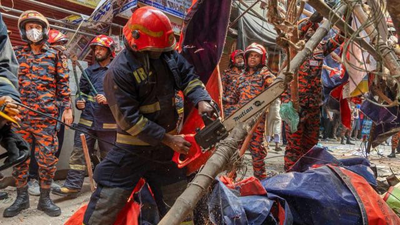 Para petugas penyelamat dan pemadam kebakaran memotong pagar bangunan yang jatuh ke jalan untuk membuka jalur setelah gempa di Dhaka, Bangladesh, Jumat (21/11/2025). (Dok. AP/Abdul Goni)